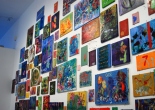 cluster of small paintings on a white wall