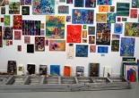cluster of small paintings on a white wall